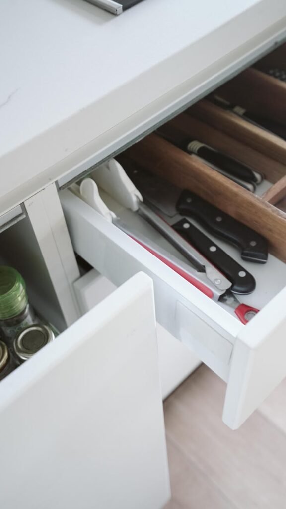 Neatly arranged kitchen drawer with knives and utensils, showcasing effective organization.