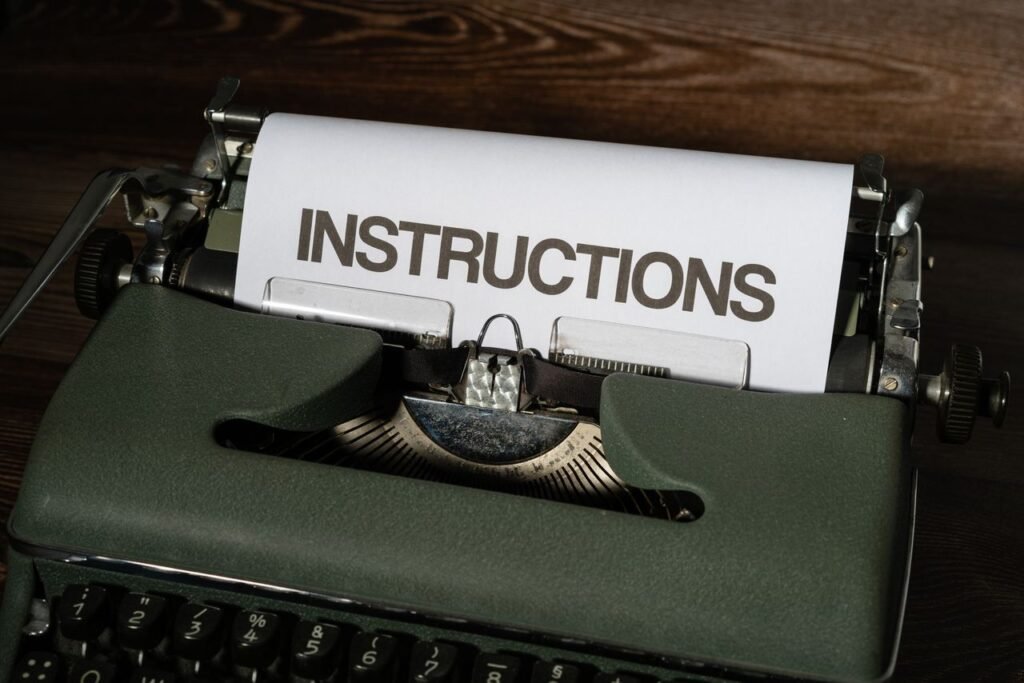 Close-up of a vintage typewriter printing the word 'INSTRUCTIONS' on paper sheet.